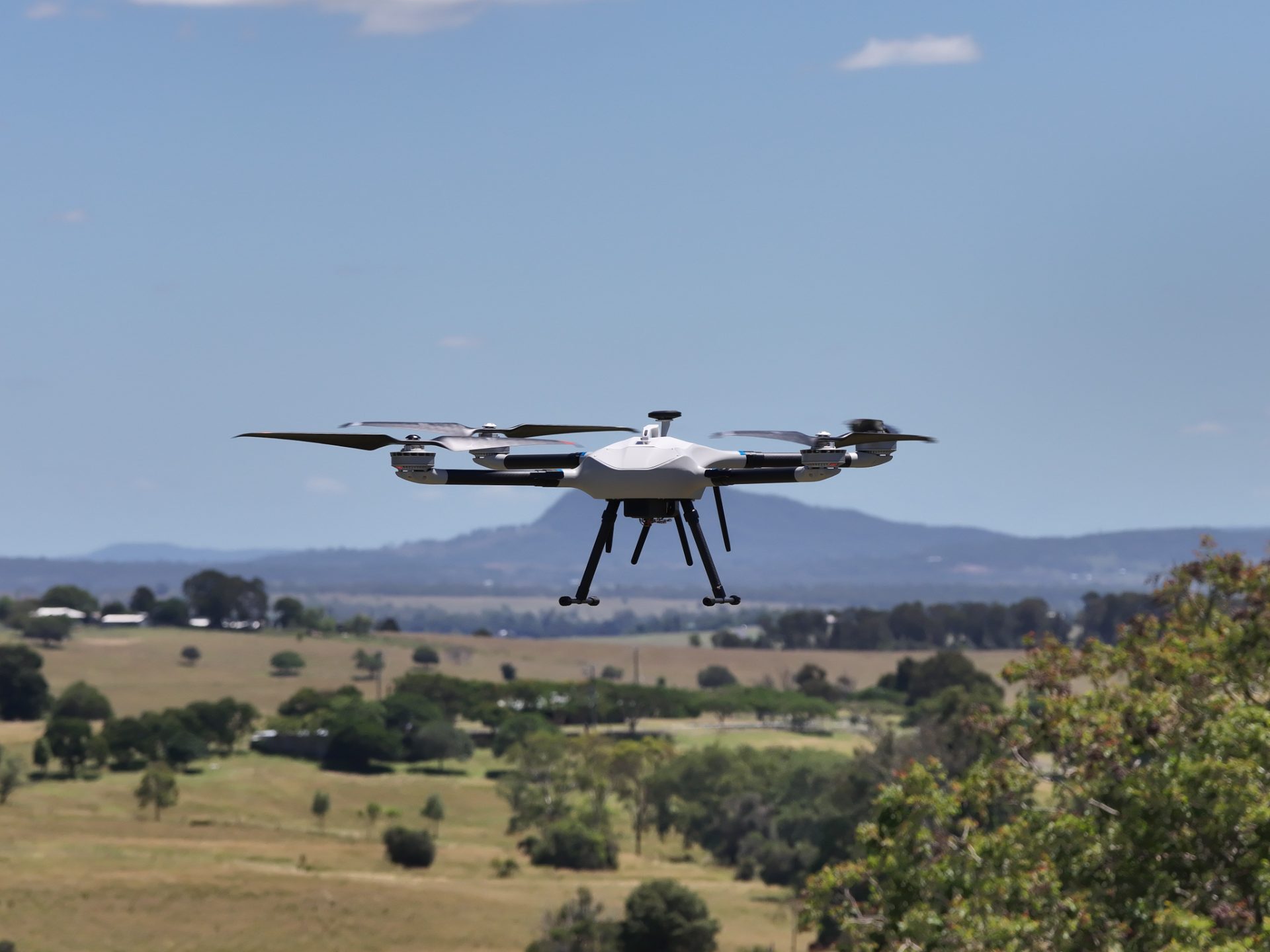 Multirotor airframe in flight over open farmland